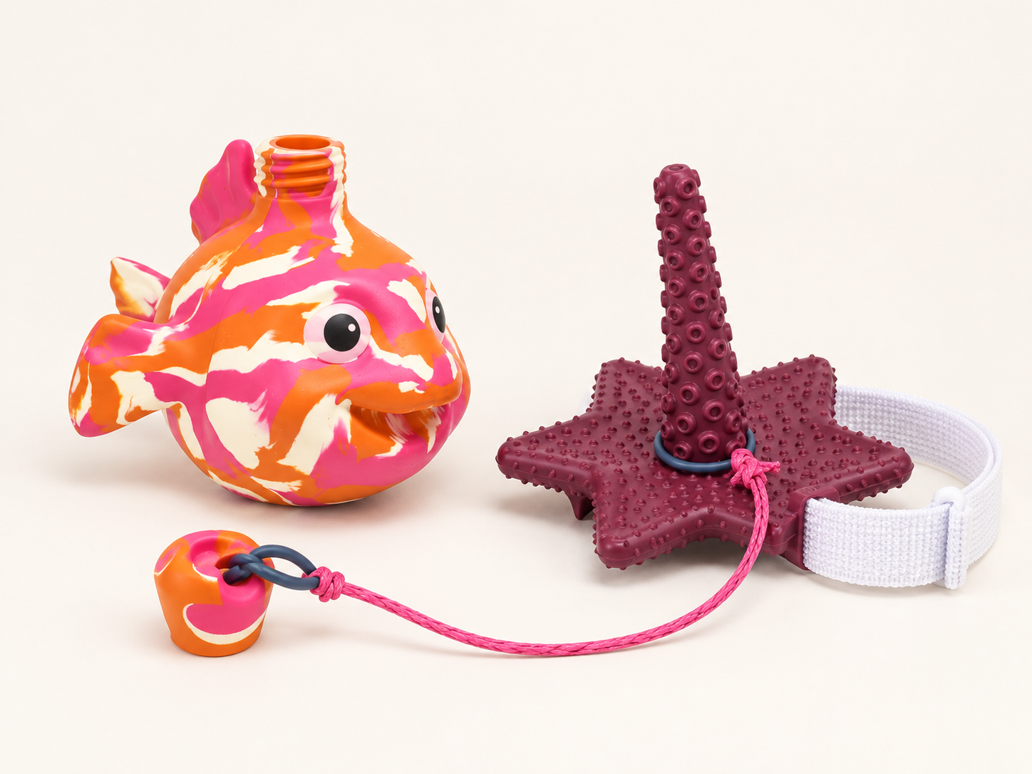 Contenu de Bilibli Solo : un poisson au goulot ouvert, une base corail cinq branches avec sa sangle blanche, une corde rose et un bouchon détaché.